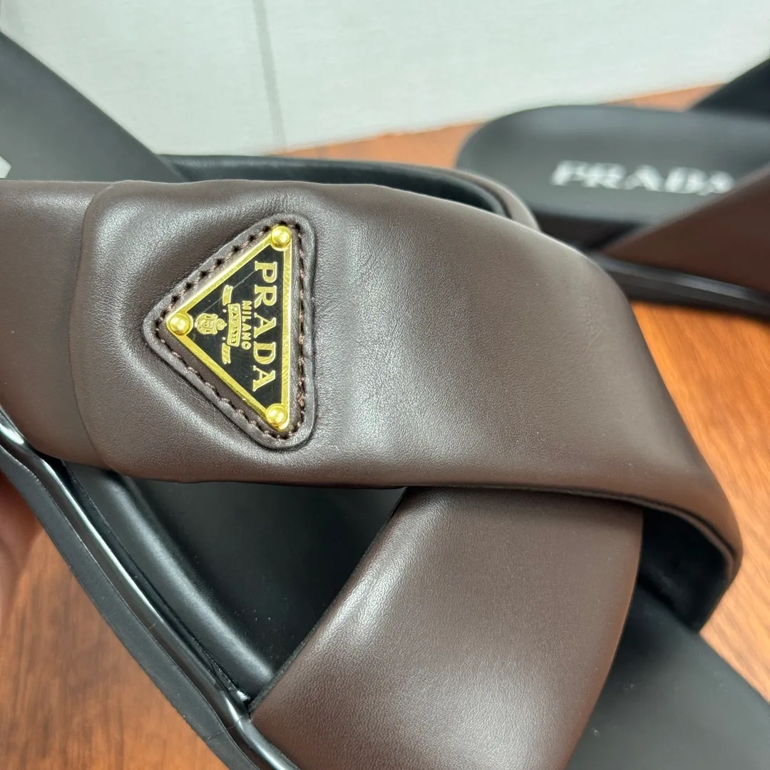 Batch 580 Prada/Prada's new men's leather cross slippers. Velcro closure can finely adjust the size. Calf leather light luxury slippers. Thick soft calf leather wraps the upper. Fat but soft rubber lazy style, soft and comfortable, excellent foot feel. Genuine leather bottom layer, cross style, with a Velcro closure buckle, easy to adjust the appropriate size, and a perfect fit for the wearing experience. The enamel gold triangle logo highlights the brand's classic features. Lightweight rubber thin sole, high foot comfort! Complete package! Size: 39-40-41-42-43-44-45 Leather shoe size Item number: 2X7132 Brown